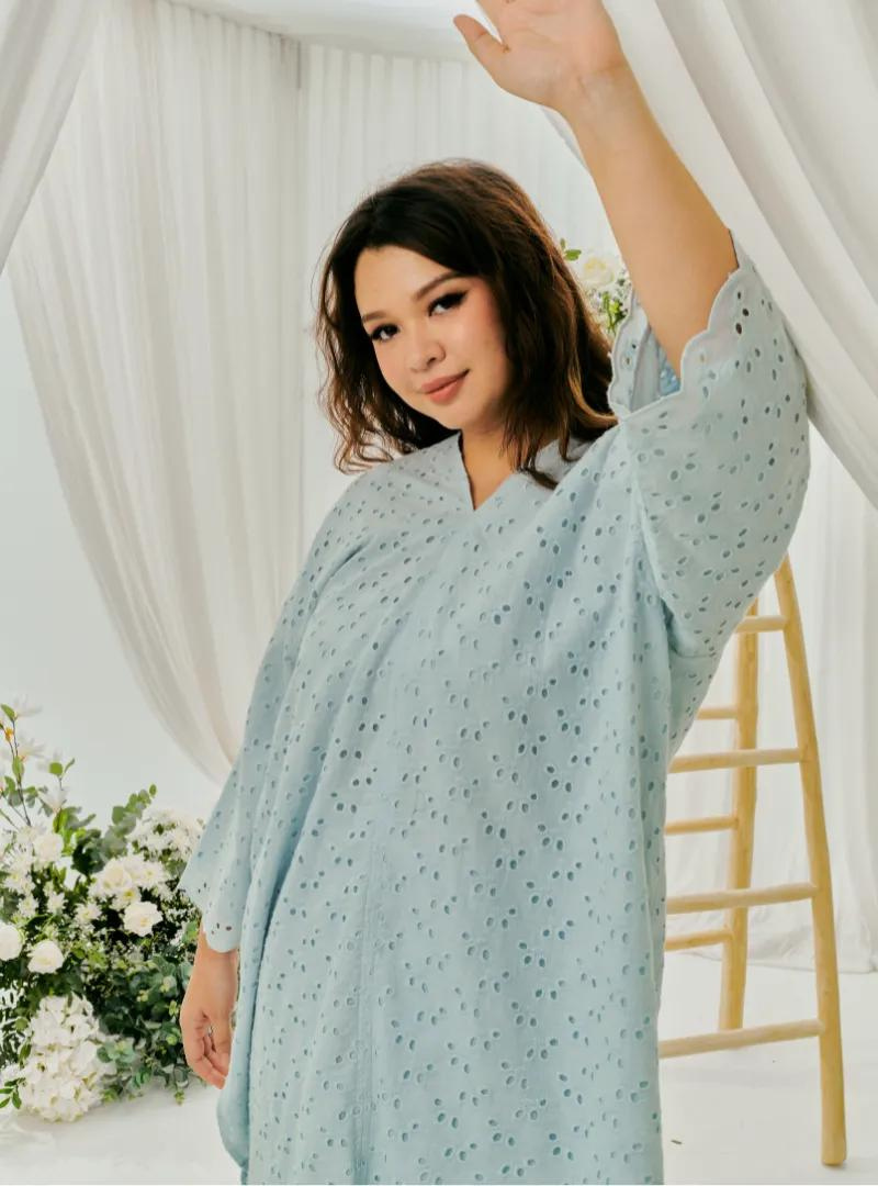 A woman dressed in Baby Blue Tun Yasmin Eyelet Oversized Kurung