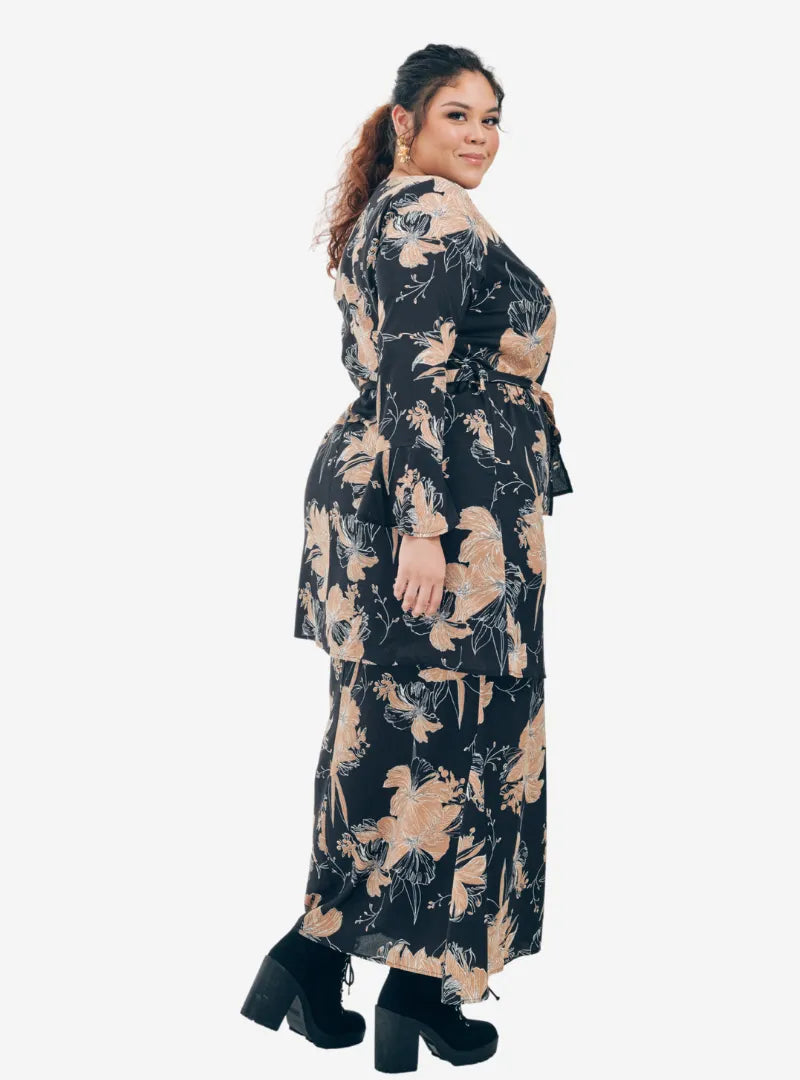 A woman dressed in Black Aneesa Flower Printed Kurung