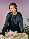 A woman dressed in Black Tun Seroja Satin Kurung Pahang