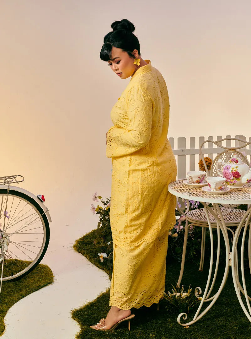 A woman dressed in Buttermilk Yellow Tun Sabrina Eyelet Kebarung