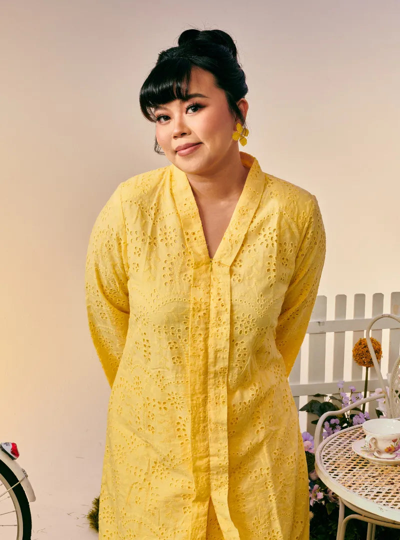 A woman dressed in Buttermilk Yellow Tun Sabrina Eyelet Kebarung