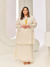 A woman dressed in Champagne Tun Tipah Dotted Wrap Kurung