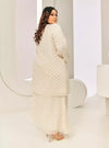 A woman dressed in Champagne Tun Tipah Dotted Wrap Kurung