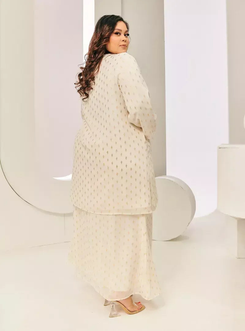 A woman dressed in Champagne Tun Tipah Dotted Wrap Kurung