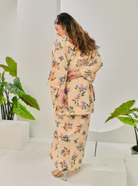 A woman dressed in Cream Corn Lily Vintage Opah Kurung