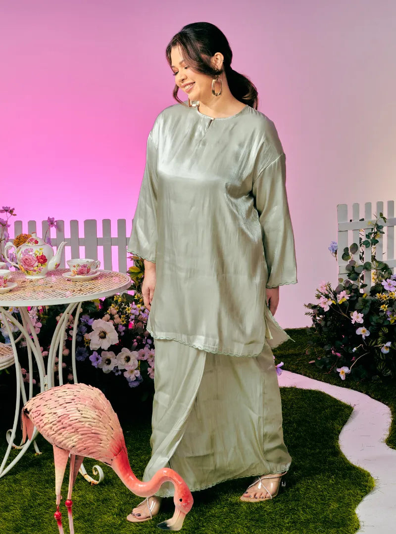 A woman dressed in Dusty Green Tun Seroja Satin Kurung Pahang
