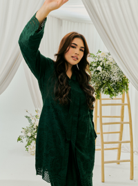 A woman dressed in Emerald Green Tun Sabrina Eyelet Kebarung