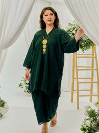 A woman dressed in Emerald Tun Yasmin Embroidered Eyelet Oversized Kurung