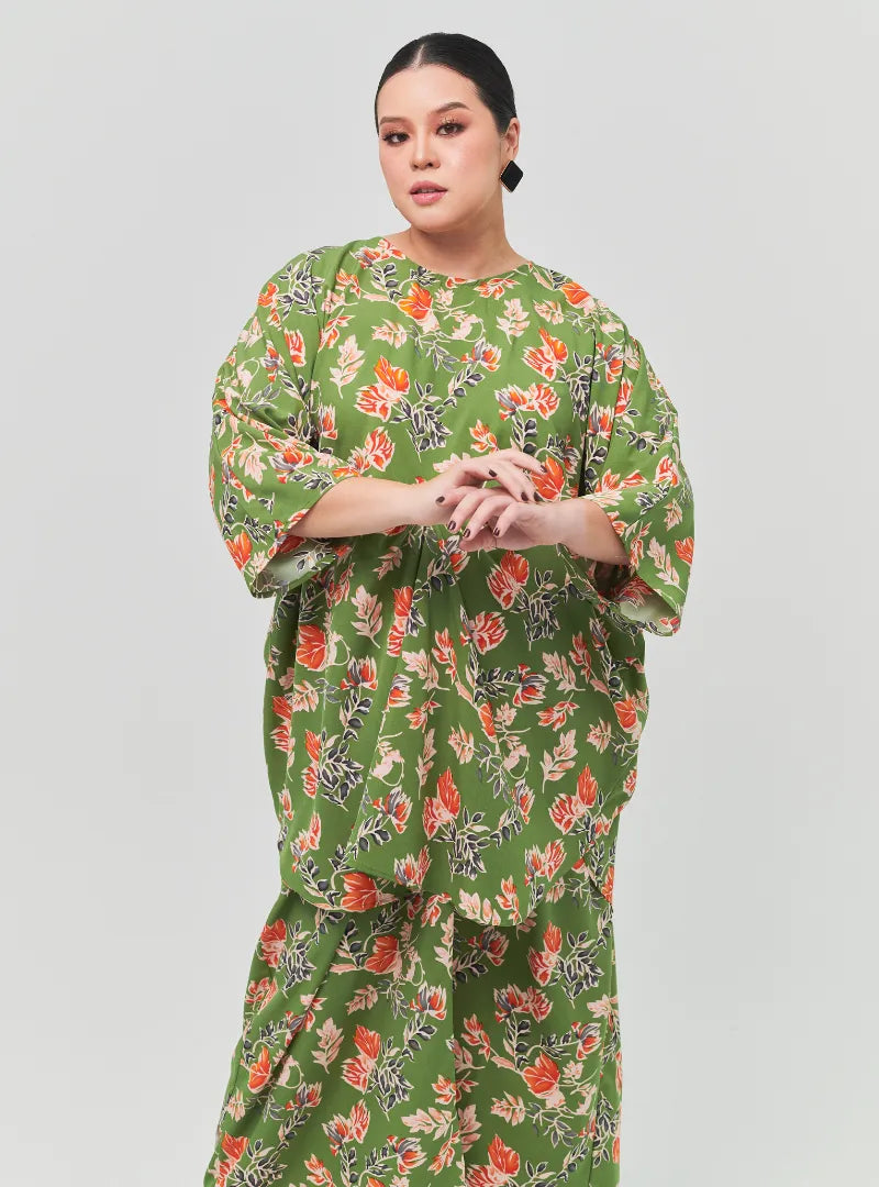 A woman dressed in Jowo Green The Vintage Opah Kurung