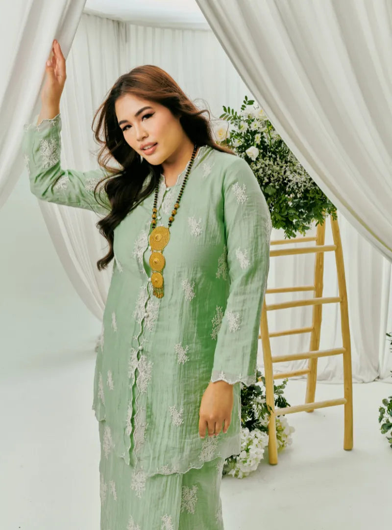 A woman dressed in Mint Green Tun Saloma Klasik Kebaya Kurung