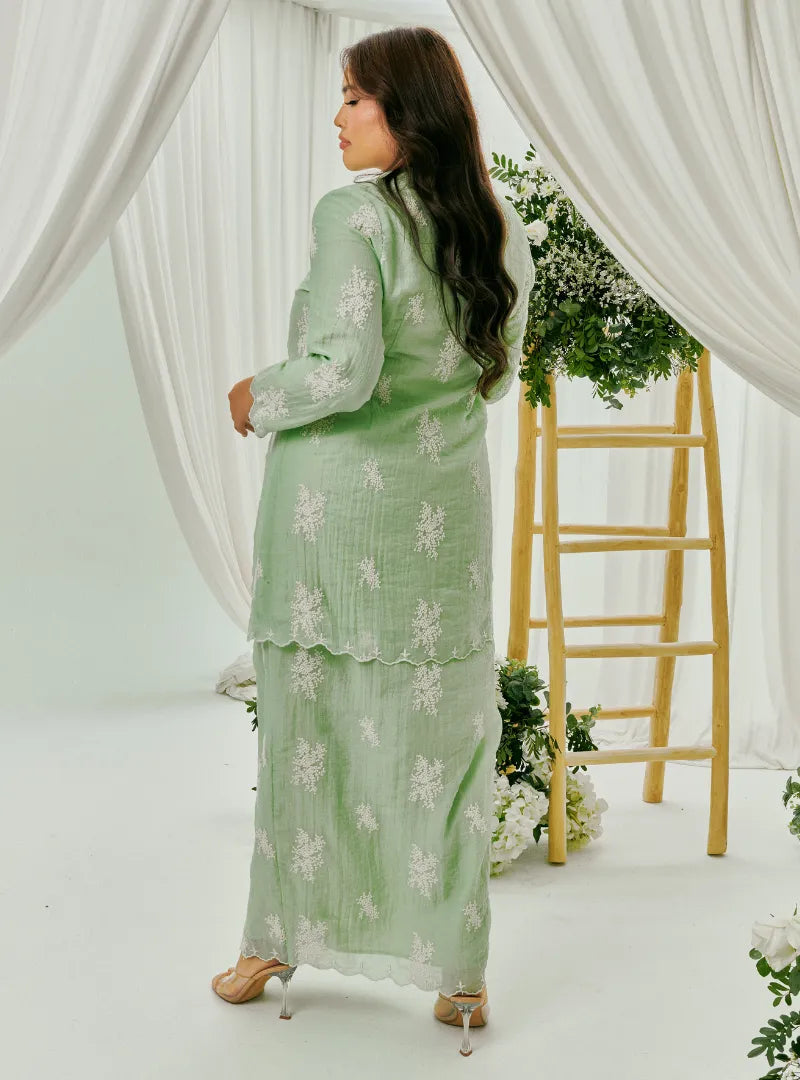 A woman dressed in Mint Green Tun Saloma Klasik Kebaya Kurung