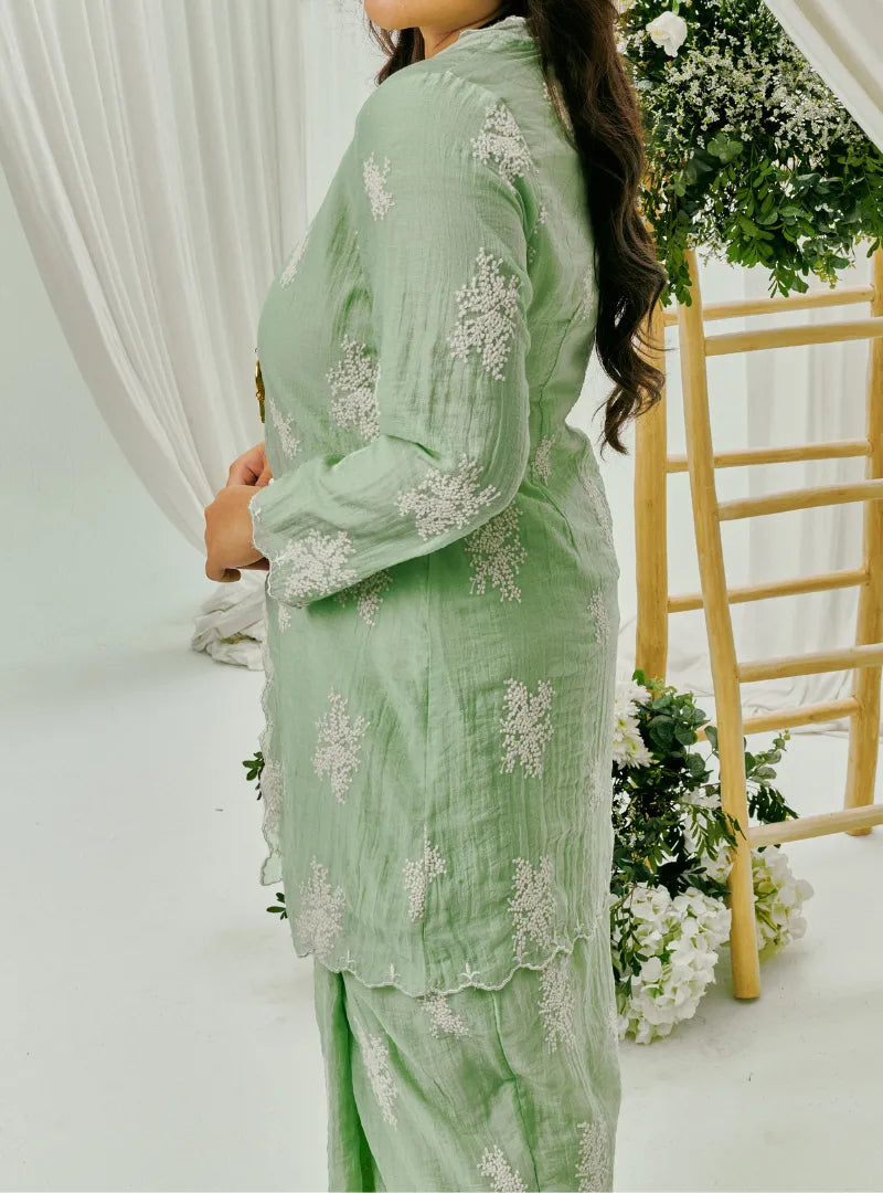 A woman dressed in Mint Green Tun Saloma Klasik Kebaya Kurung