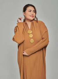 A woman dressed in Mocha Tun Aimellia Pleated Maxi Dress