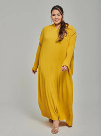 A woman dressed in Mustard Tun Aimellia Pleated Maxi Dress