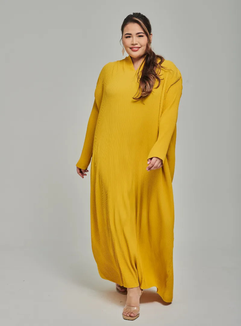 A woman dressed in Mustard Tun Aimellia Pleated Maxi Dress