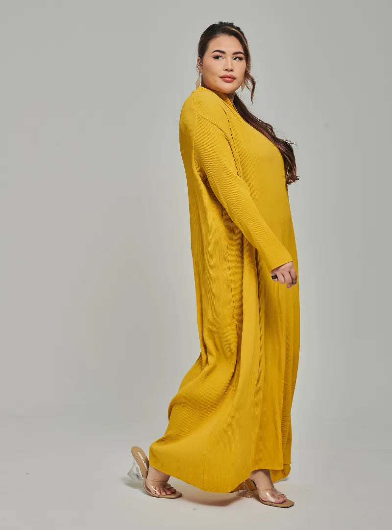 A woman dressed in Mustard Tun Aimellia Pleated Maxi Dress