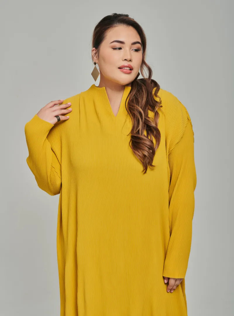 A woman dressed in Mustard Tun Aimellia Pleated Maxi Dress