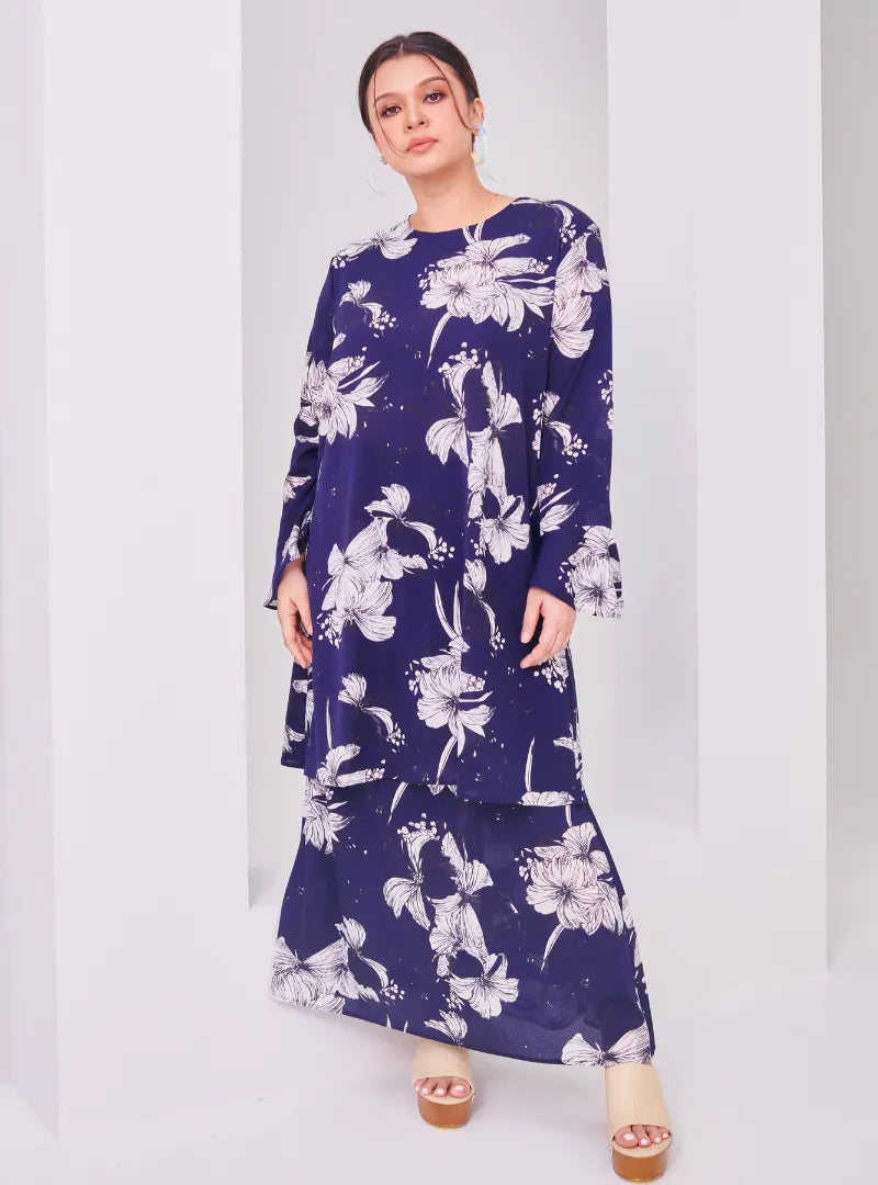 A woman dressed in Navy Aneesa Flower Printed Kurung