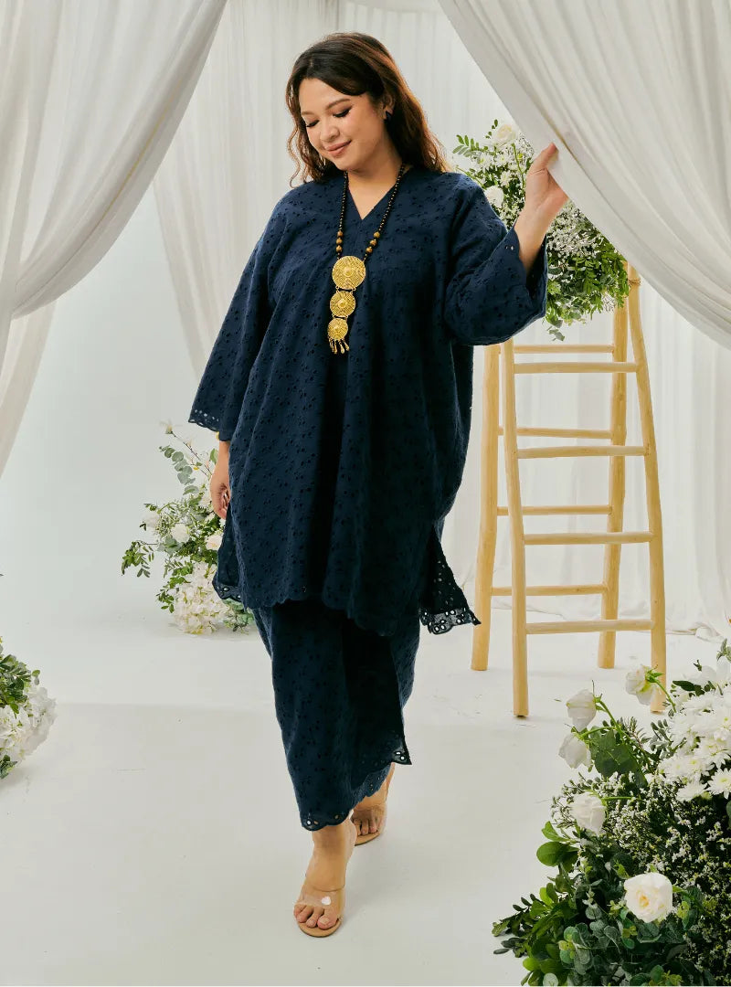 A woman dressed in Navy Tun Yasmin Eyelet Oversized Kurung