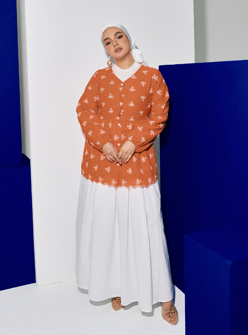 A woman dressed in Orange Tun Ava Embroidered Top