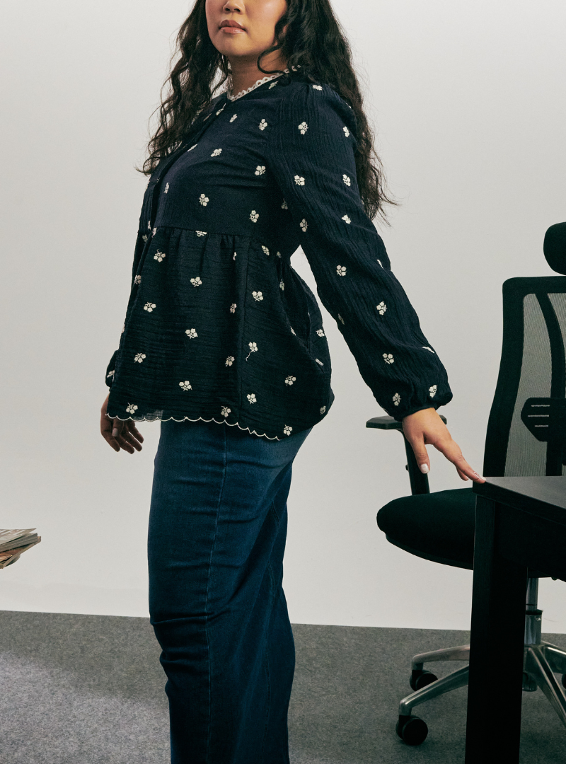 A woman dressed in Oxford Blue Arya Peplum Embroidered Top