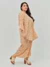 A woman dressed in Peach Fairy The Vintage Opah Kurung