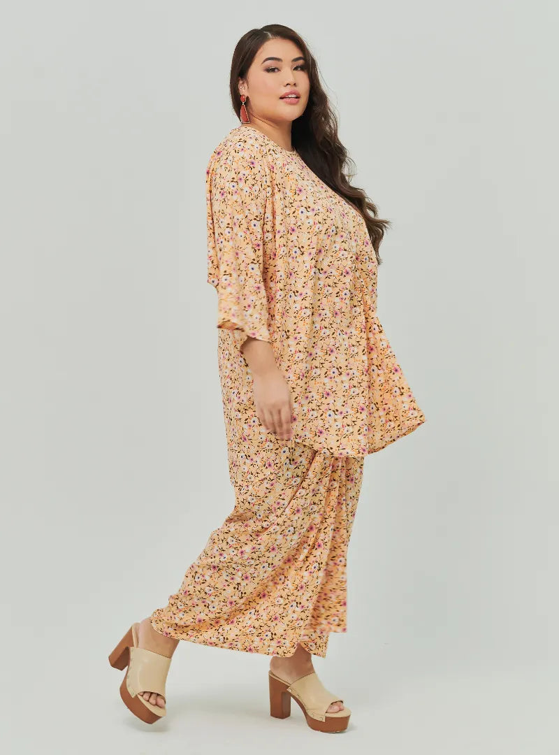 A woman dressed in Peach Fairy The Vintage Opah Kurung
