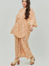 A woman dressed in Peach Fairy The Vintage Opah Kurung