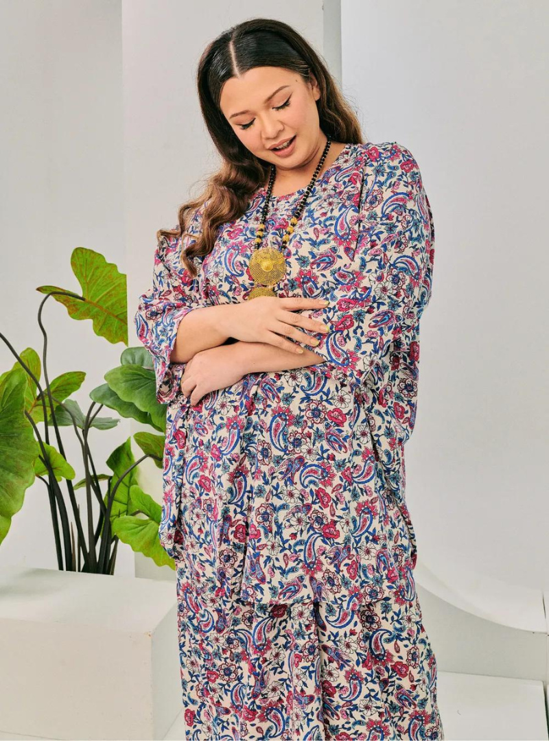 A woman dressed in Pink Bunga The Vintage Opah Kurung