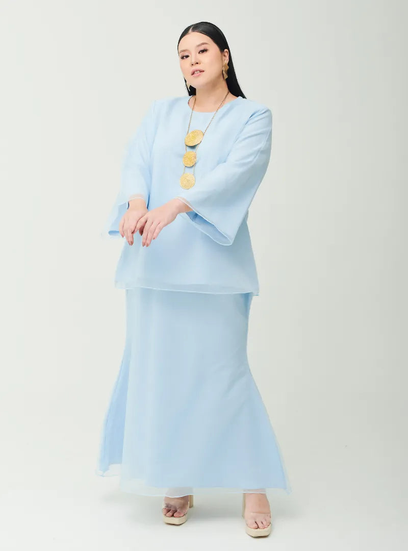 A woman dressed in Powder Blue Tun Aminah Organza Basic Kurung