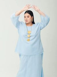 A woman dressed in Powder Blue Tun Aminah Organza Basic Kurung