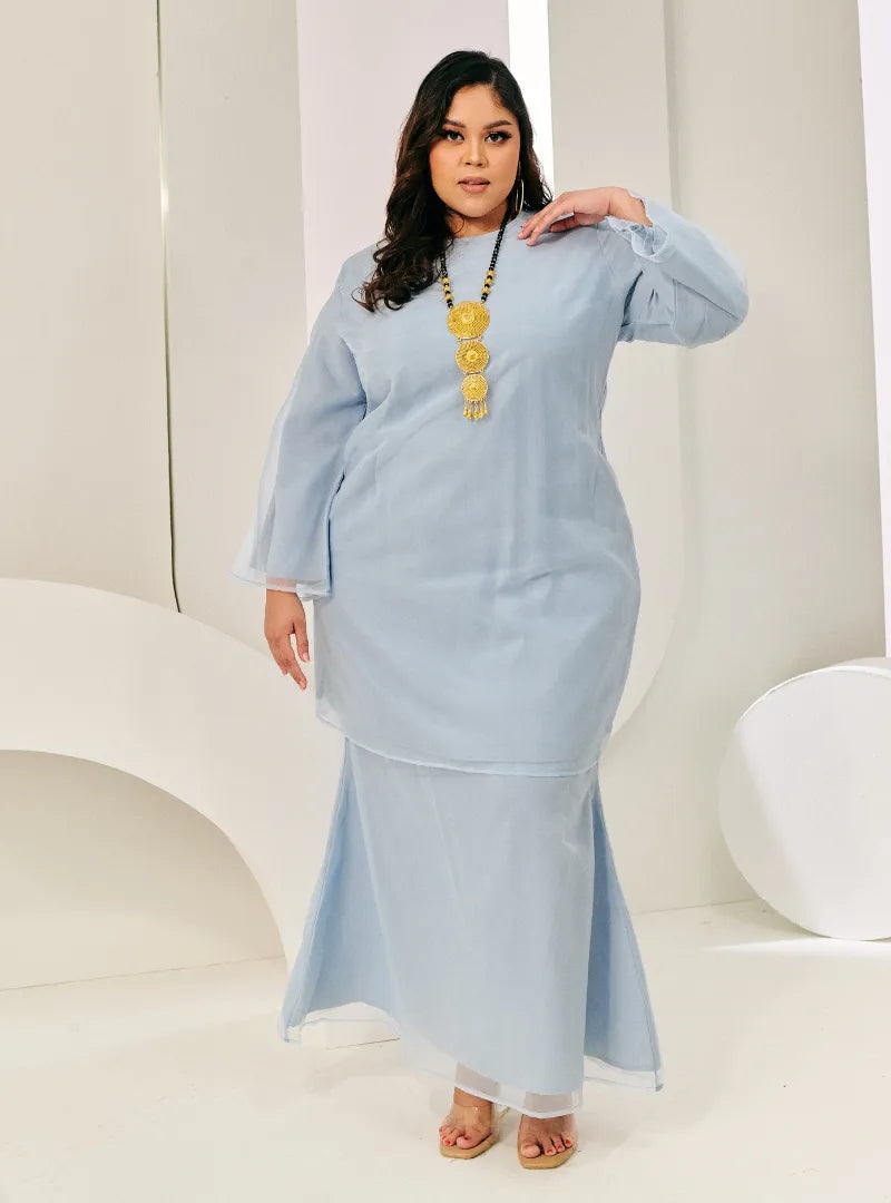 A woman in dressed in Powder Blue Tun Sharimah Organza Kurung