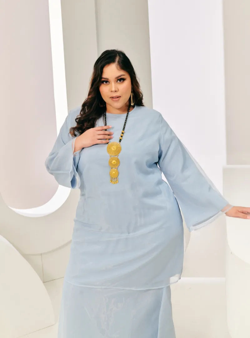 A woman in dressed in Powder Blue Tun Sharimah Organza Kurung