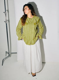 A woman dressed in Pucuk Pisang Maisara Eyelet Ruffles Top