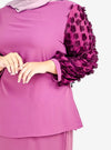 A woman dressed in Raisin High Neck Butterfly Kurung