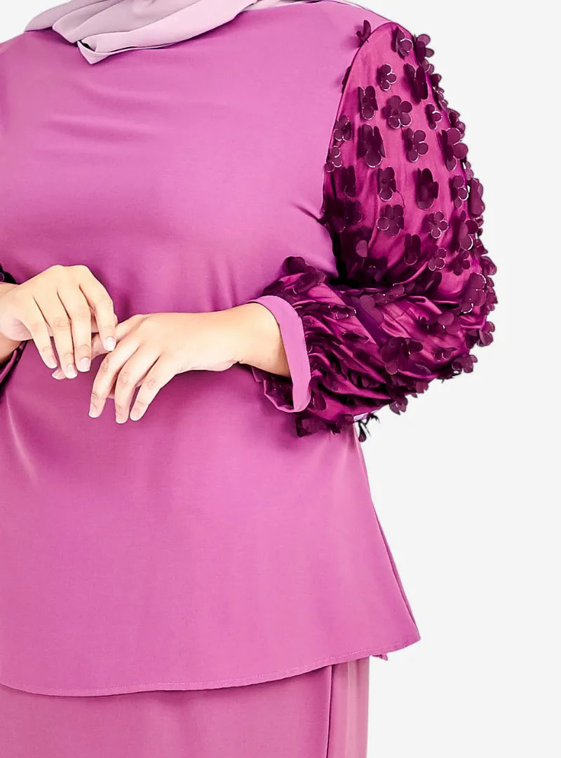 A woman dressed in Raisin High Neck Butterfly Kurung