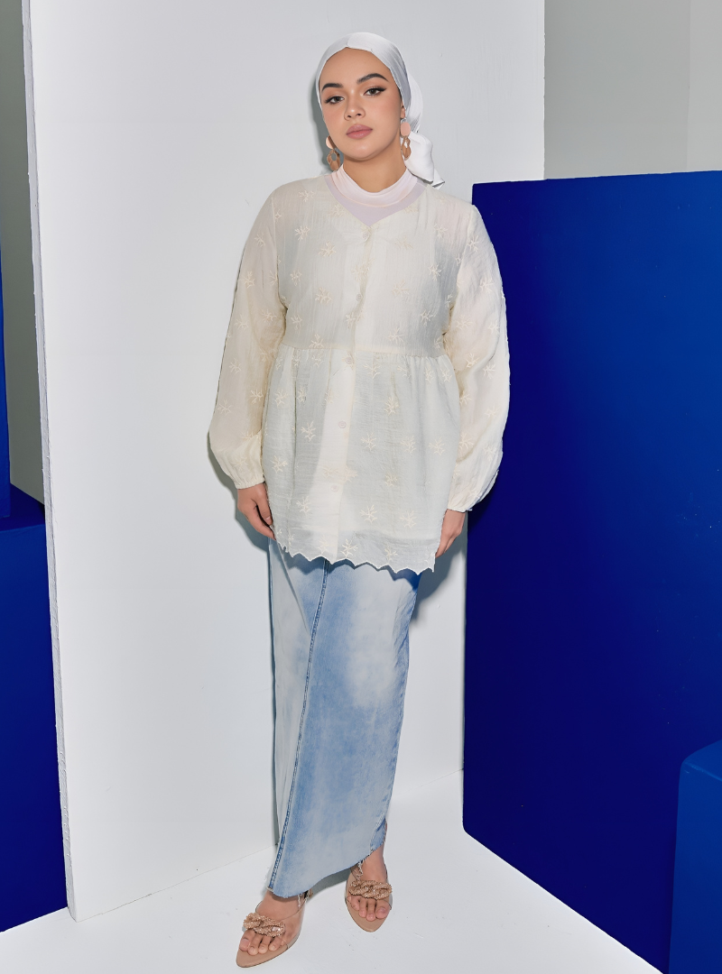 A woman wearing Rice Tun Ava Peplum Embroidered Top