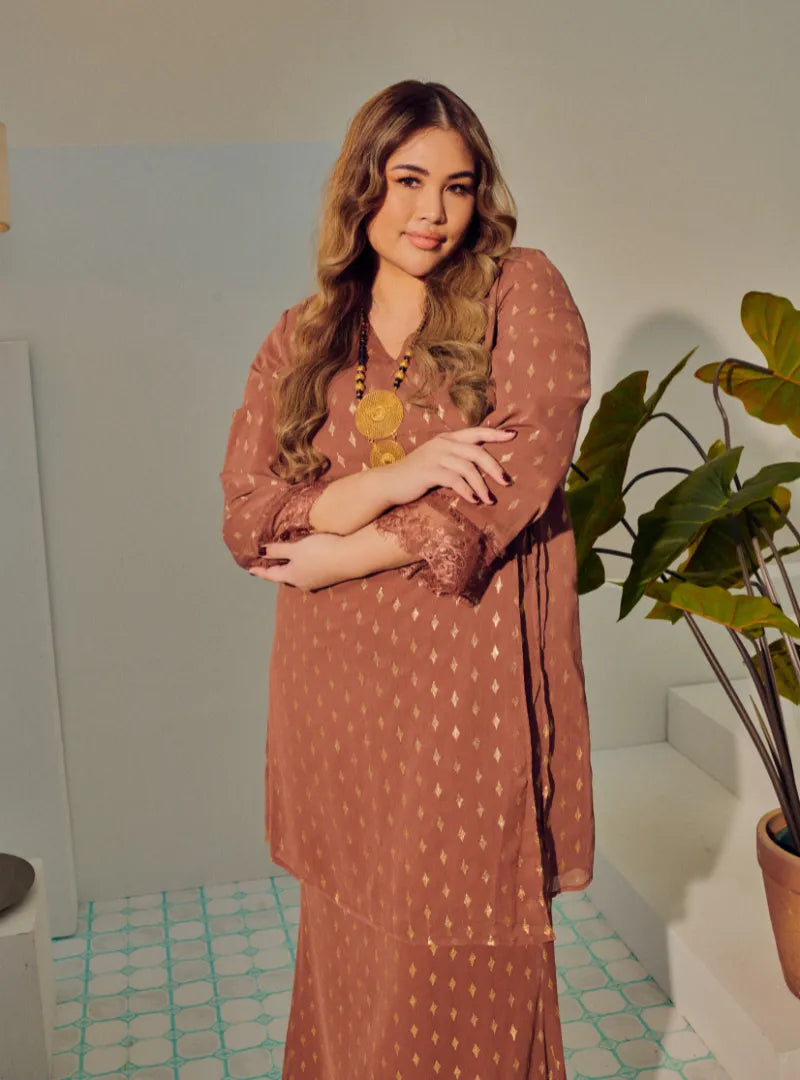 A woman dressed in Rosewood Tun Tipah Dotted Wrap Kurung