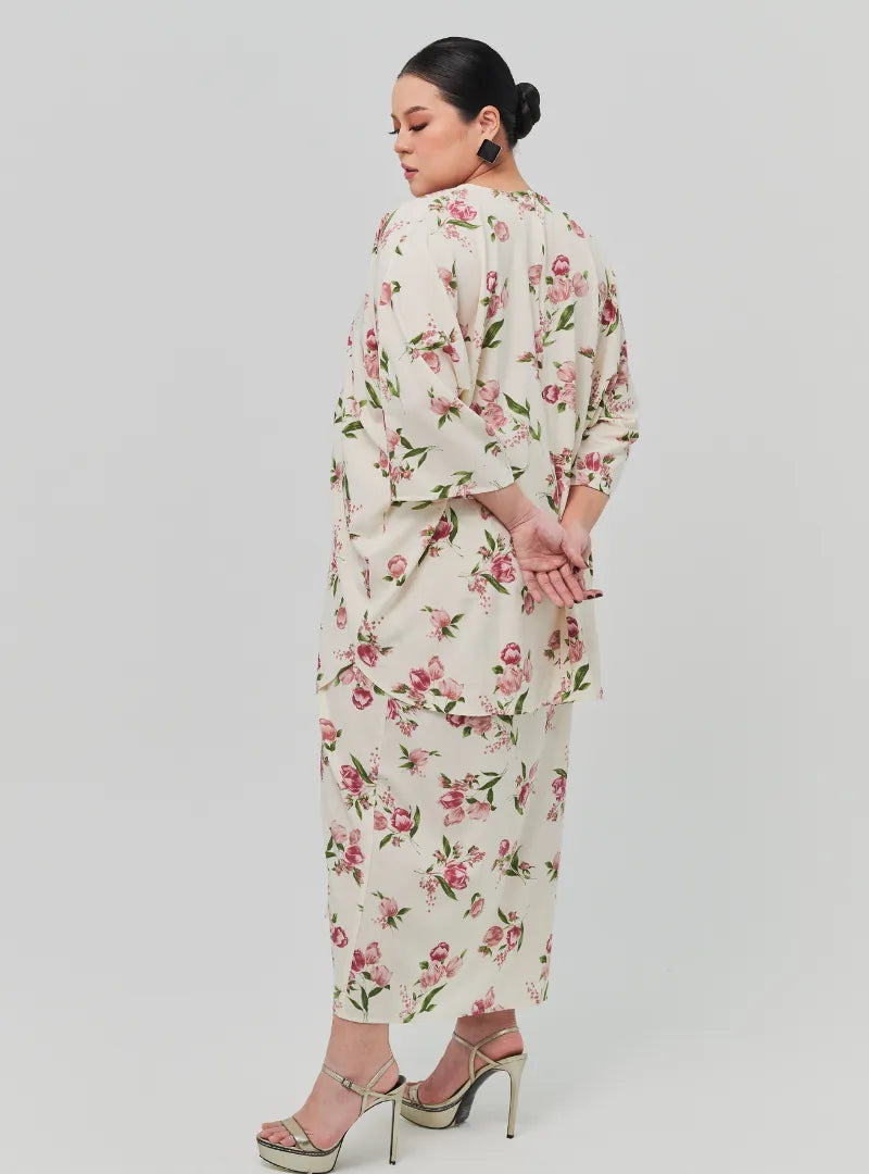 A woman dressed in Sand Lily The Vintage Opah Kurung