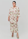 A woman dressed in Sand Lily The Vintage Opah Kurung