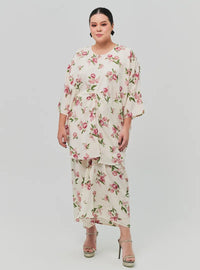 A woman dressed in Sand Lily The Vintage Opah Kurung