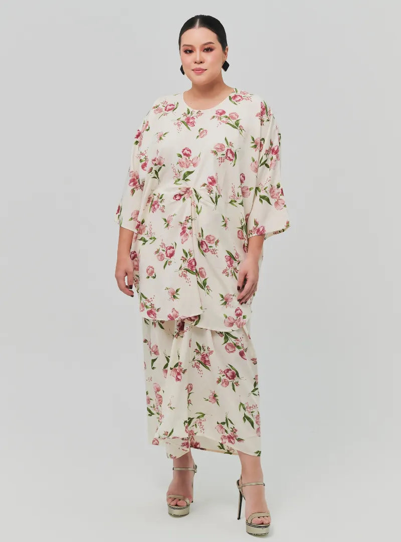 A woman dressed in Sand Lily The Vintage Opah Kurung