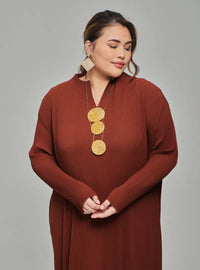 A woman dressed in Walnut Tun Aimellia Pleated Maxi Dress