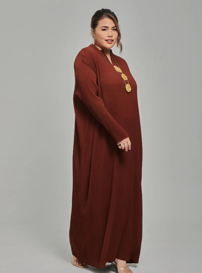 A woman dressed in Walnut Tun Aimellia Pleated Maxi Dress